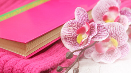 Obraz na płótnie Canvas Pink book, beautiful orchid and scarf