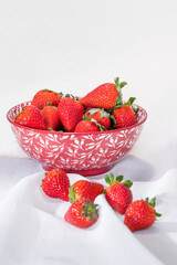 Strawberries in a bowl behind other strawberries