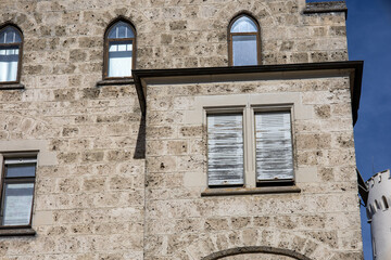 Fototapeta na wymiar Schloss mit alten Fenster und Fensterläden sowie der Sonne die sich refletkiert