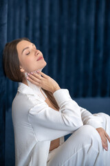 Young woman with tapes on her neck sitting and looking contented