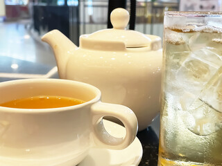 Selective focus on Chinese oolong tea in tea cup, tea pot and glass of ice tea with blurry environment background.