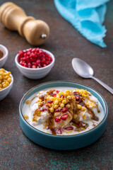 Indian tasty street food Dahi Bhalla or  Dahi Vada garnished with tamarind sauce and pomegranate seeds 