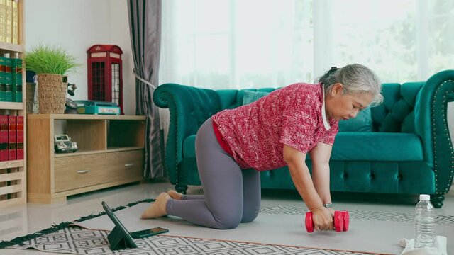 Healthy senior woman exercise one arm dumbbell row