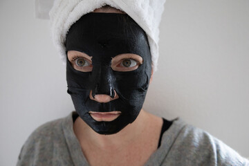 Schwarze Gesichtsmaske für Feuchtigkeit im Gesicht am Wellnesstag