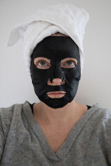 Schwarze Gesichtsmaske für Feuchtigkeit im Gesicht am Wellnesstag
