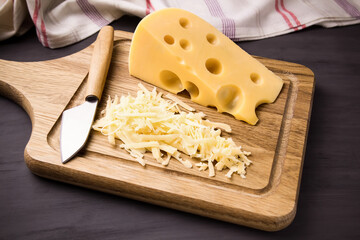 Fresh cheese on a wooden board. On black background.