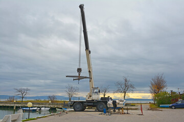 A hydraulic mobile suspended boat lift or hoist with a sling. Located in an out-of-season marina in northern Italy
