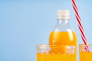 Glass of orange juice with red straw on table
