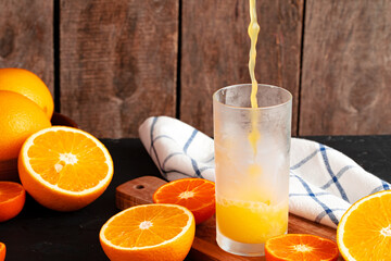 Orange juice pouring from the bottle into the glass