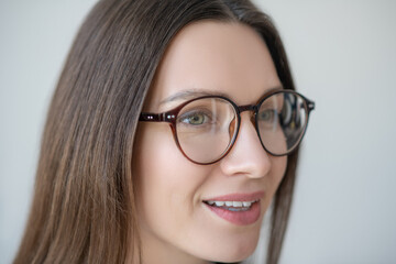 Headshot of long-haired woman in eyewear looking positive