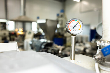 Close-up of a monometer against the background of units and equipment in production