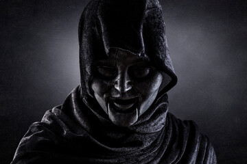 Portrait of a scary figure in hooded cloak