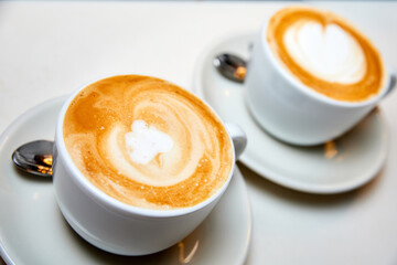 Two cups of Latte coffee in a white cups. Close-up, selective focus.
