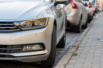 rows of cars parked along the roadside in crowded city