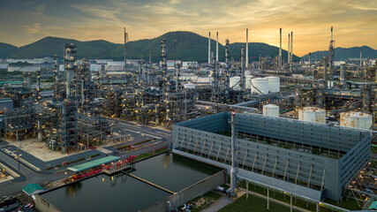 Oil refinery plant from industry zone, Aerial view oil and gas petrochemical industrial, Refinery factory oil storage tank and pipeline steel at twilight.