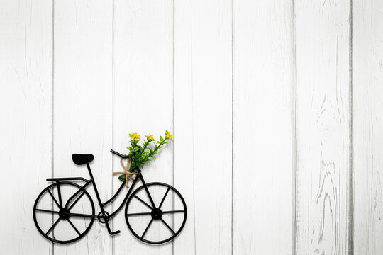 Bicycle with flowers on wooden background