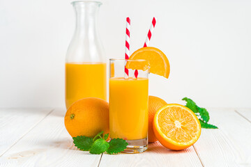 Orange juice and fresh fruit on a white background.
