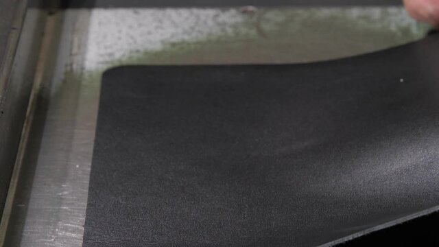 Skilled tailor measures leather slice width with rusty tool