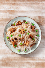 Konjac pasta with mushrooms and green peas, shot from above