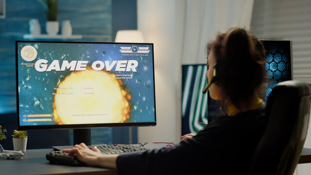 Sad pro woman gamer with headset losing video games streaming space shooter video game from gaming studio. Game over for cyber player performing online cybersport competition using powerful computer