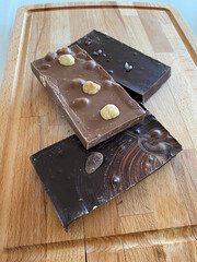 Photo of chocolates on a wood background. Dark, milk and white chocolate.