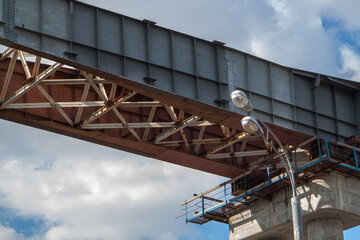 Naklejka premium close-up view of railway bridge under construction. connection of steel powerful straight crossbar, bridge connection, metal architecture