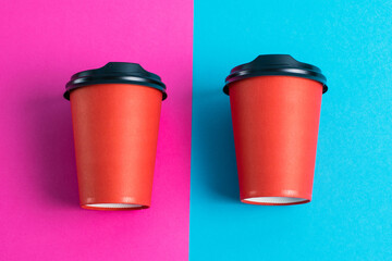 Red paper cups with plastic lids on bright paper backdrops copy space