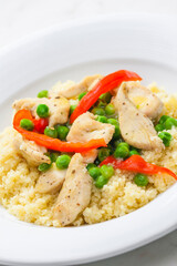 Fototapeta na wymiar poultry meat with green peas, red pepper and couscous