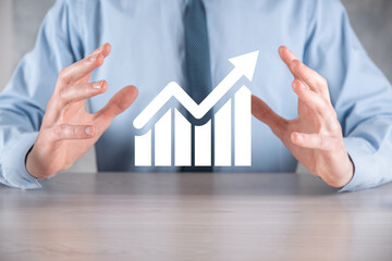 Businessman man holding a graph with positive profits growth. plan graph growth and increase of chart positive indicators in his business.more profitable and growing.