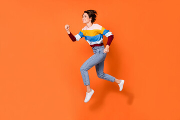 Fototapeta na wymiar Full length body size profile side view of lovely cheerful girl jumping running isolated over bright orange color background