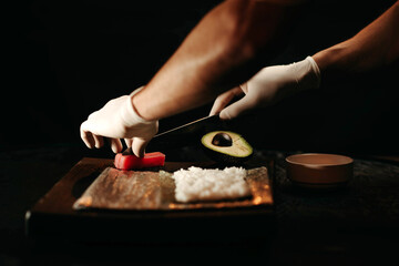 Obraz na płótnie Canvas Close-up view of process of preparing rolling sushi.