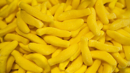 Jelly bananas as a background. Fruity-fresh jelly with banana. Yellow sweet background. Banana flavored gum, chewing gum