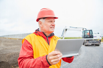 Construction manager with tablet PC on the construction site in road construction
