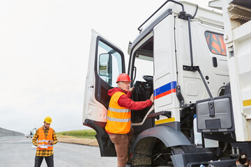 Truck driver climbs into his truck with a delivery