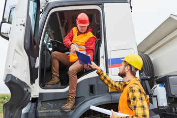 Truck driver brings delivery to construction site with worker © Robert Kneschke