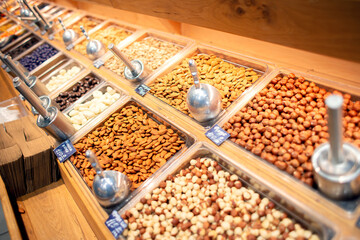 Many different nuts are sold on the counter in the store.