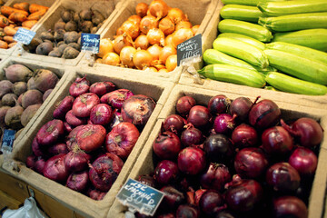 Selling vegetables on the counter in a self-service store. Different types of onions on sale