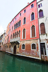 Fototapeta na wymiar Beautiful narrow canal with gondolas and small boats and historical buildings in Venice, Italy