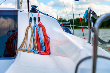 Detail of a sailboat deck with a winch and nylon ropes. Sailing yacht rigging equipment
