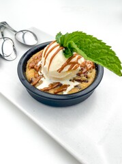 Well presented delicious gourmet dessert based on cold ice cream and cookie with hot caramel.