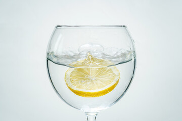 Fresh clear water with lemon and splashes on a white background