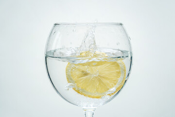 Fresh clear water with lemon and splashes on a white background
