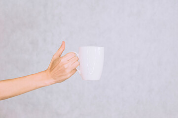 White mug for coffee, tea in the girl's hand. On a white background.