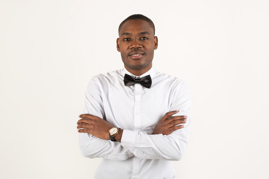 handsome young african man in white shirt and bow tie on white background 