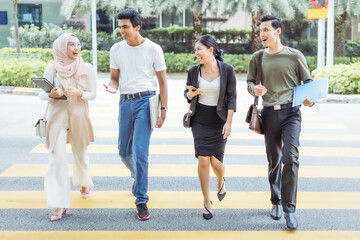 Multiracial group of people crossing the road.