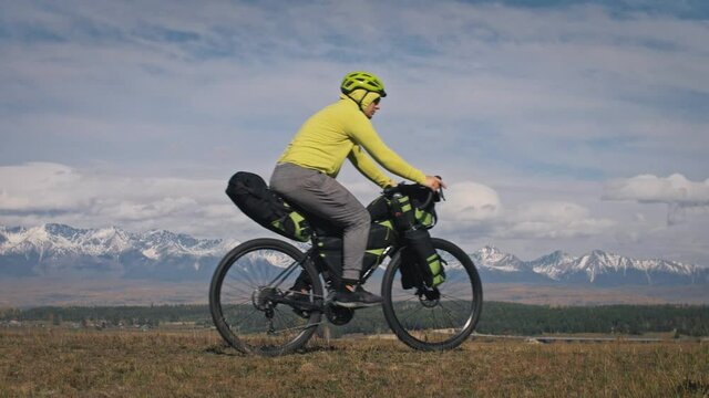 The man and woman travel on mixed terrain cycle touring with bikepacking. The love couple journey with tent in with bicycle bags. Stylish sportswear.