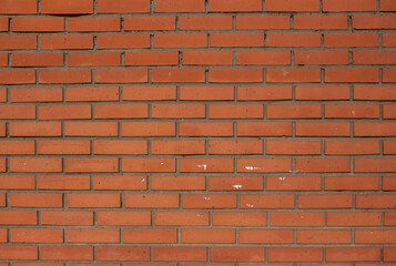 Fototapeta premium Red brick wall texture with dots and traces of white paint on it