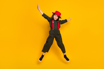 Fototapeta na wymiar Full length body size view of pretty cheerful girl jumping wearing khaki clothes good mood isolated over bright yellow color background