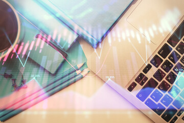 Double exposure of forex graph drawing over desktop background with computer. Concept of financial analysis. Top view.