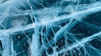Blue transparent clear smooth ice with deep cracks. Natural landmark of Russia.